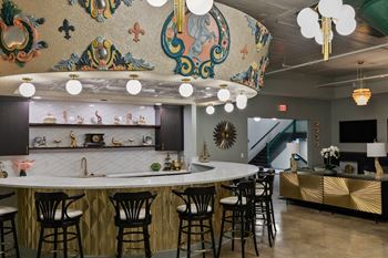Community kitchen with curved marble island and globe lighting